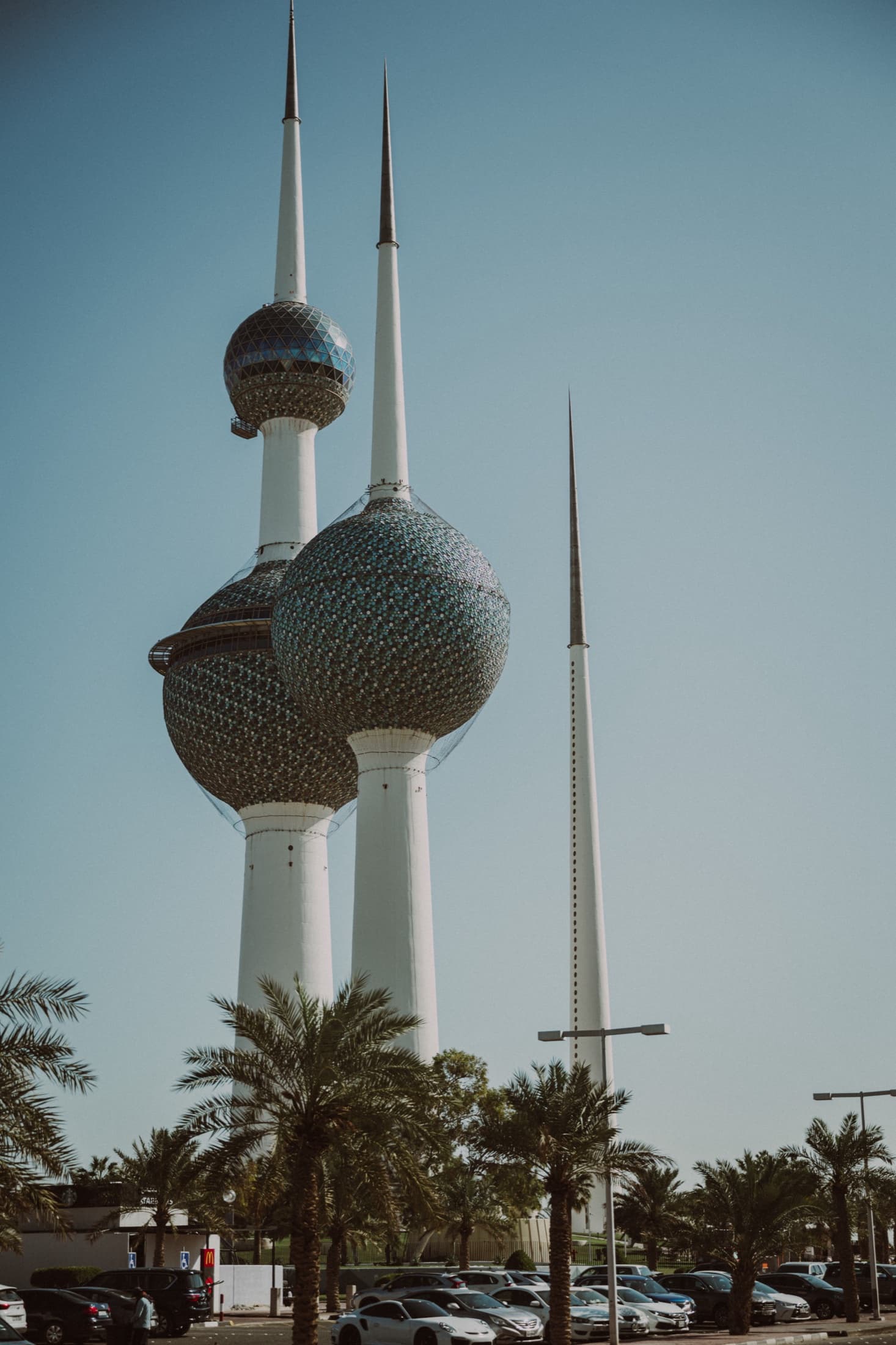 Real photograph of Kuwait Towers framed against a clear blue sky